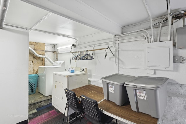 basement with washing machine and clothes dryer and electric panel