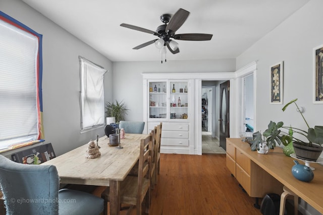 dining space with a ceiling fan and wood finished floors