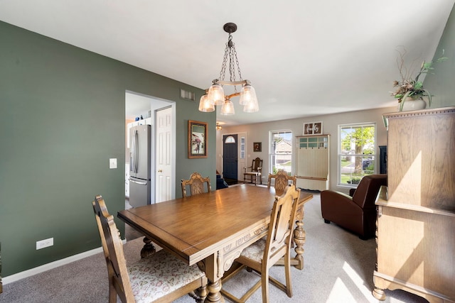 1125 Ironwood Ct, Elgin, IL 60120 - dining area with light colored carpet, a chandelier, and baseboards