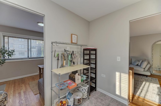 hall with baseboards and wood finished floors