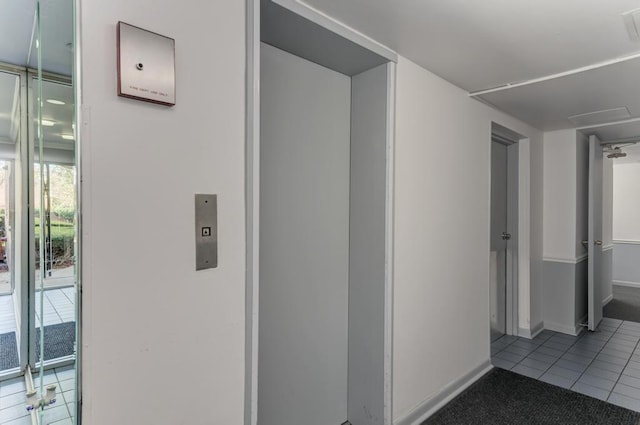 corridor featuring tile patterned flooring and baseboards