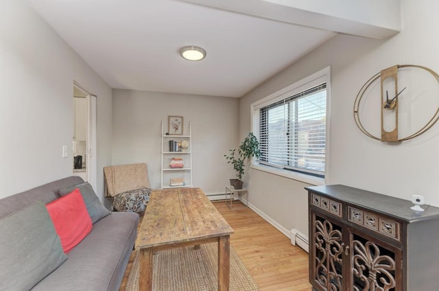 office space featuring light wood finished floors, baseboard heating, a baseboard radiator, and baseboards