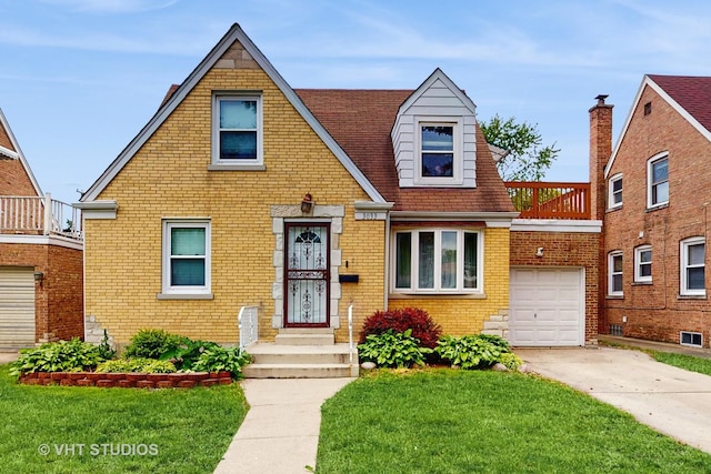 3033 Dora St, Franklin Park, IL 60131 - tudor home featuring brick siding, a front yard, driveway, and a garage
