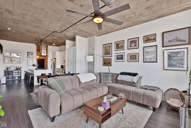 living area with a ceiling fan and wood finished floors