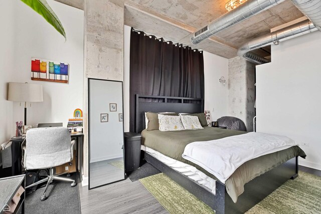 bedroom with wood finished floors, a desk, and baseboards