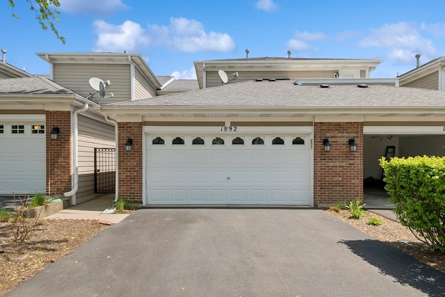 1892 Keystone Pl, Schaumburg, IL 60193 - townhome / multi-family property with brick siding, driveway, an attached garage, and a shingled roof