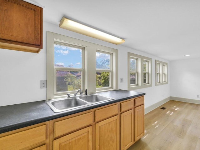 413 E Lincoln St, Monticello, IL 61856 - kitchen with a sink, dark countertops, light wood-style flooring, and baseboards