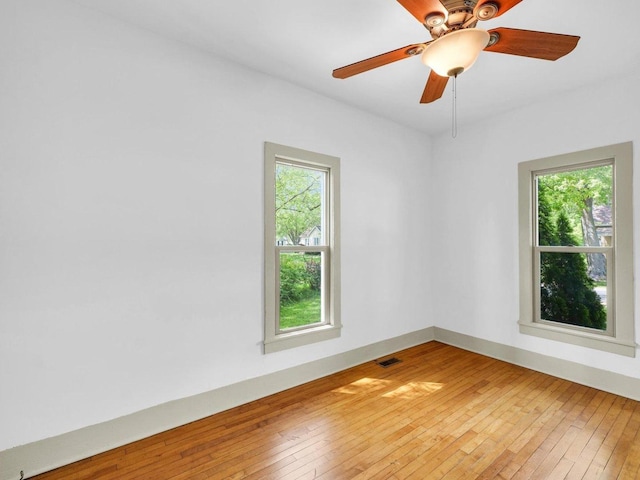 413 E Lincoln St, Monticello, IL 61856 - unfurnished room with plenty of natural light, light wood-type flooring, ceiling fan, and baseboards