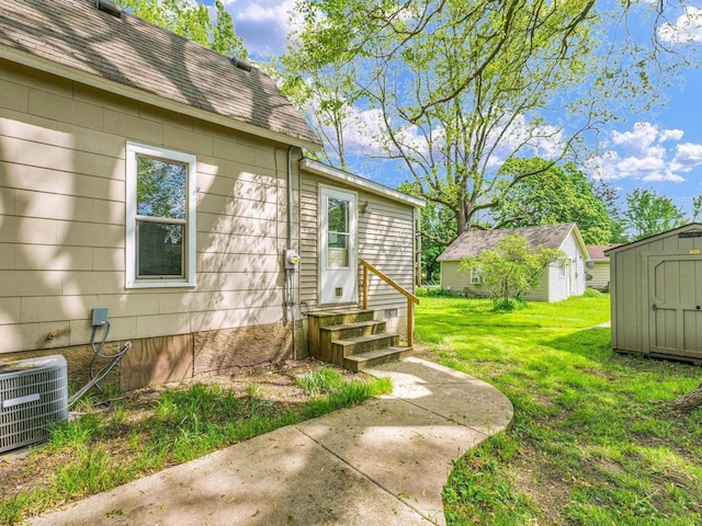 413 E Lincoln St, Monticello, IL 61856 - property entrance with central AC unit, a lawn, and roof with shingles