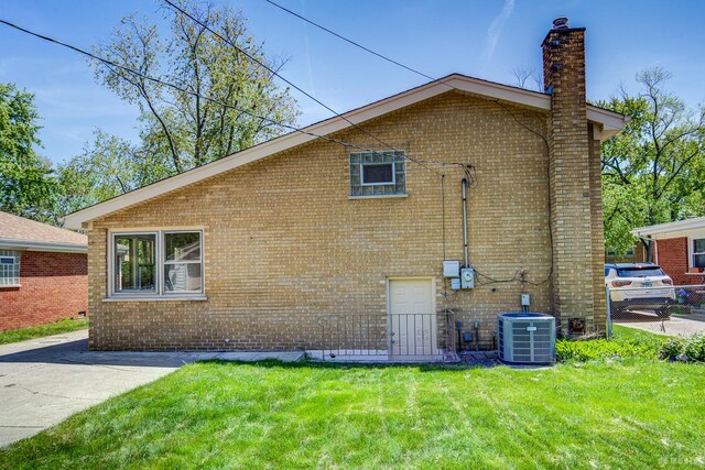 15320 Harding Ave, Midlothian, IL 60445 - view of side of property featuring central AC unit, brick siding, a chimney, and a lawn