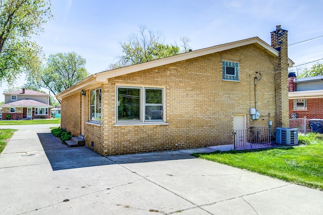 15320 Harding Ave, Midlothian, IL 60445 - view of property exterior with brick siding, a patio area, a chimney, central AC, and fence