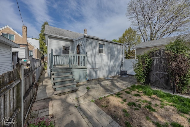 3525 N Ottawa Ave, Chicago, IL 60634 - rear view of property featuring a gate, fence, a wooden deck, a chimney, and central air condition unit