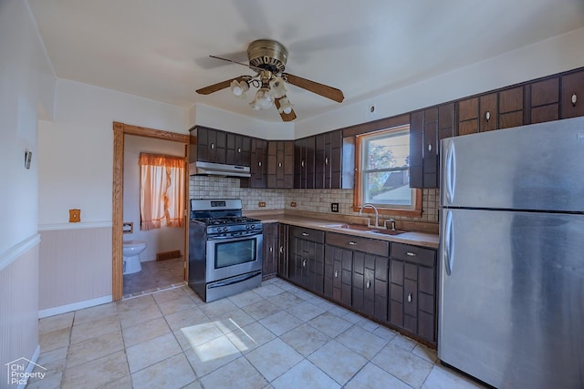 3525 N Ottawa Ave, Chicago, IL 60634 - kitchen with appliances with stainless steel finishes, under cabinet range hood, a sink, ceiling fan, and dark brown cabinetry