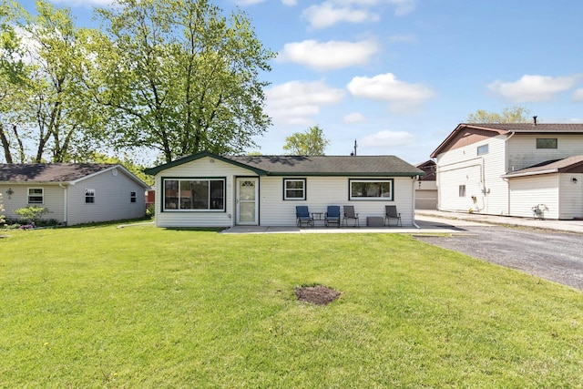 rear view of property with a patio and a yard