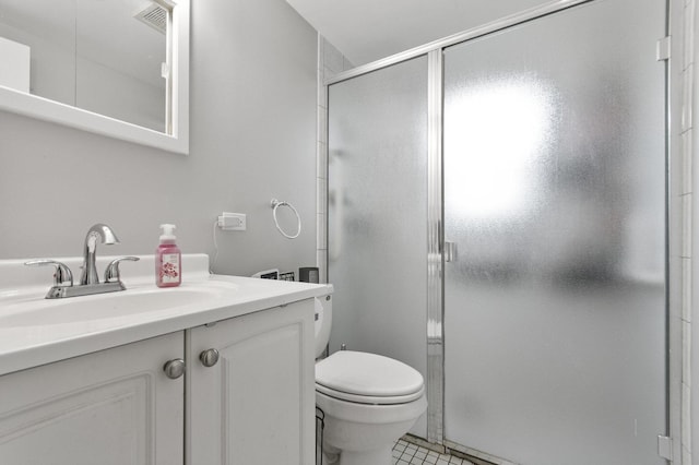 bathroom featuring a shower stall, toilet, vanity, and tile patterned floors