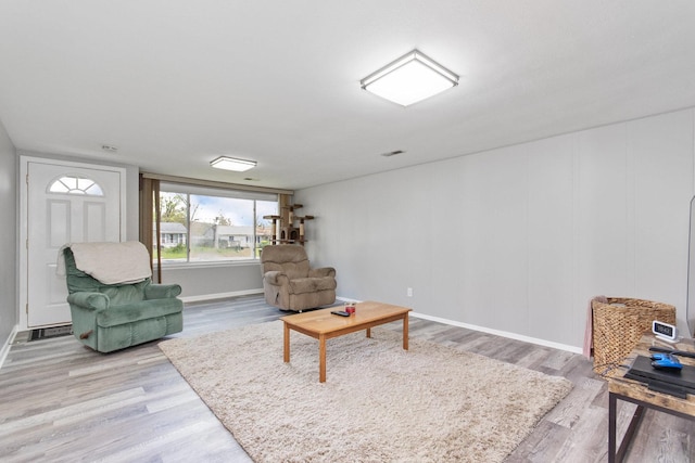 living area featuring light wood-type flooring and baseboards