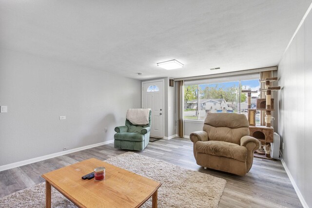 living area with light wood-type flooring and baseboards
