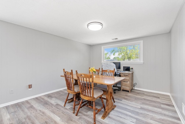 dining area with light wood-style flooring and baseboards