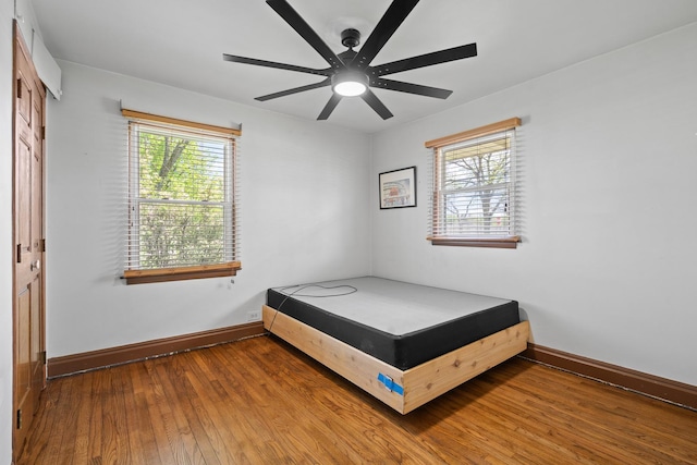 bedroom with wood-type flooring, baseboards, and ceiling fan