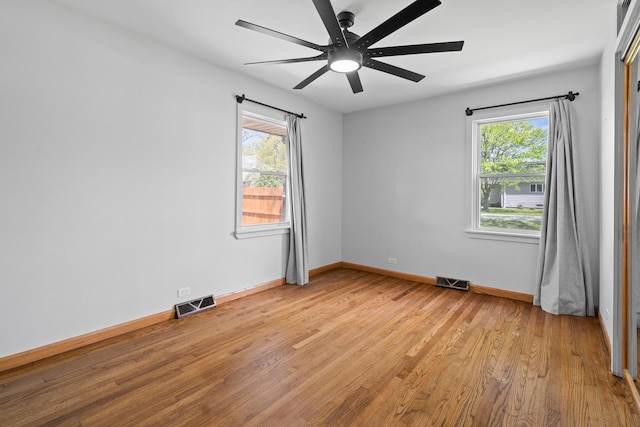 empty room with light wood finished floors, baseboards, and ceiling fan