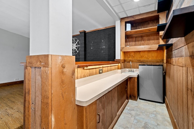 bathroom with a sink, a paneled ceiling, and baseboards