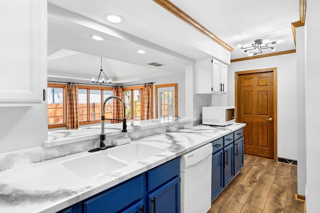 kitchen with white appliances, blue cabinetry, a chandelier, a sink, and white cabinets