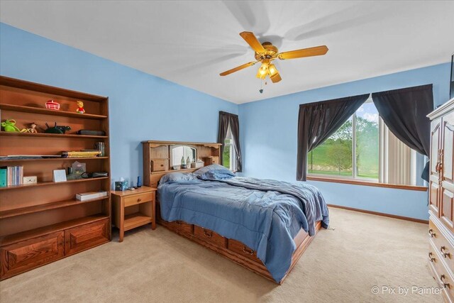 bedroom featuring light carpet, ceiling fan, and baseboards