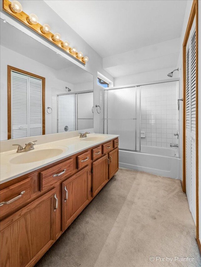 bathroom with a closet, double vanity, carpet, and enclosed tub / shower combo