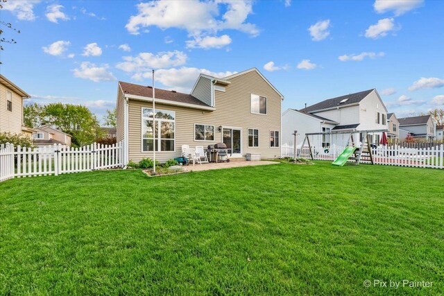 rear view of house featuring a playground and a patio area