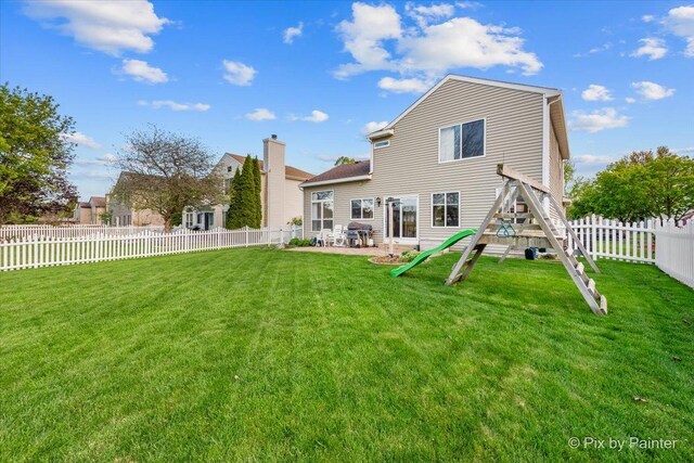 rear view of house featuring a patio and a playground