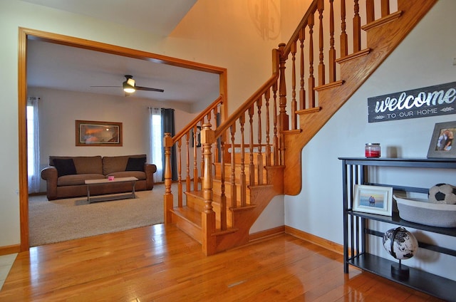 staircase featuring baseboards, plenty of natural light, and wood finished floors