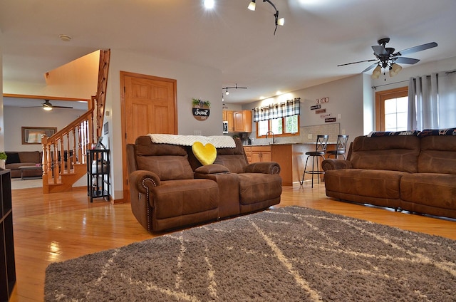 living room with ceiling fan, track lighting, and light wood-style flooring