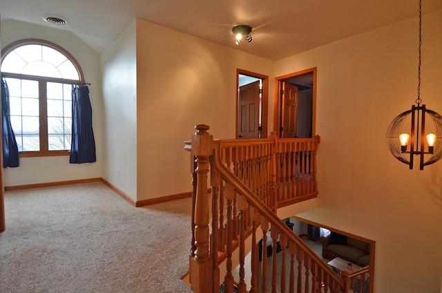 stairway with a chandelier, carpet flooring, plenty of natural light, and baseboards