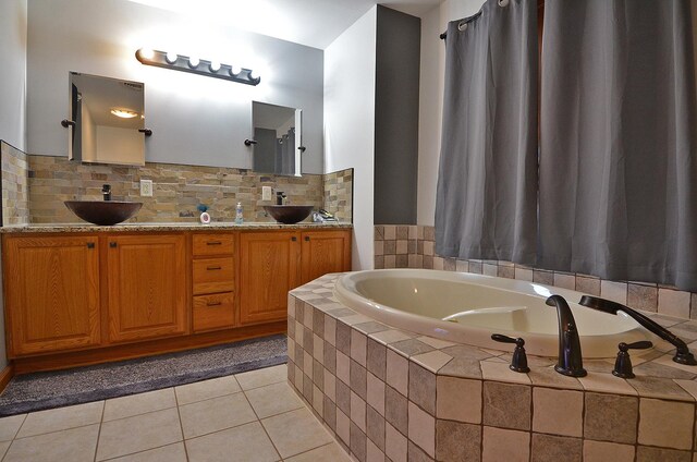 bathroom featuring tile patterned flooring, a garden tub, decorative backsplash, and double vanity