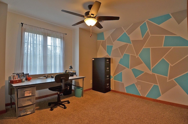 carpeted office space featuring a ceiling fan and baseboards