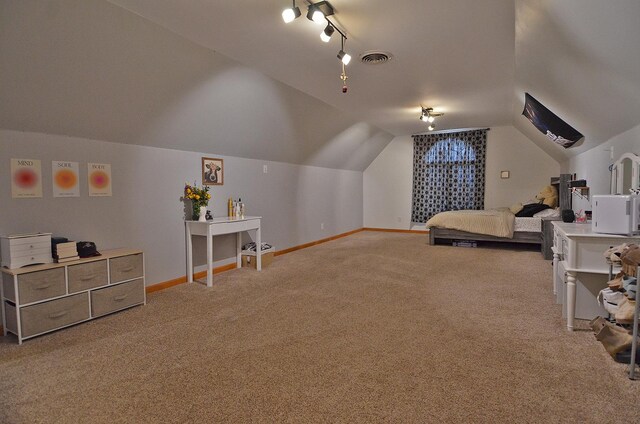 carpeted bedroom featuring vaulted ceiling, baseboards, and rail lighting