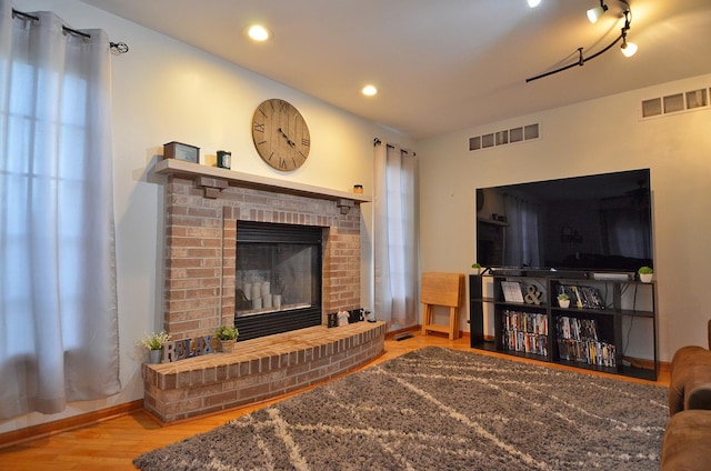 living area featuring wood finished floors, a fireplace, recessed lighting, and baseboards