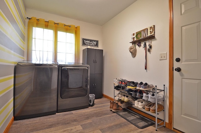 laundry area featuring washing machine and dryer, wood finished floors, and baseboards