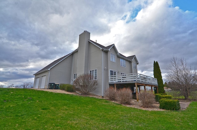 view of side of home featuring a garage, a chimney, a yard, and a deck