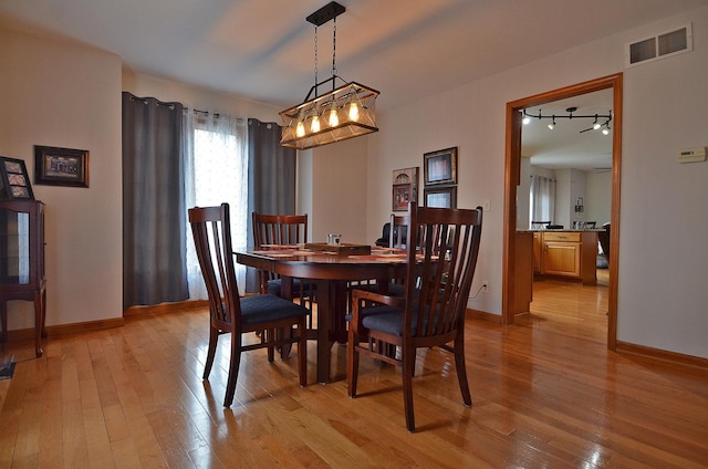 dining space with light wood-style floors and baseboards