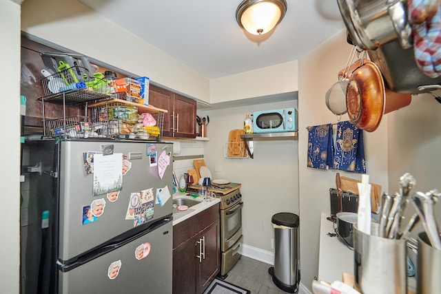 213 W Wisconsin St, Chicago, IL 60614 - kitchen with stainless steel appliances, dark tile patterned floors, open shelves, baseboards, and light countertops