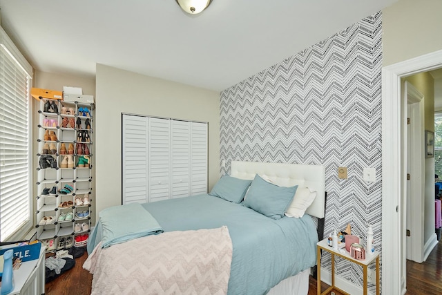 213 W Wisconsin St, Chicago, IL 60614 - bedroom featuring an accent wall, wallpapered walls, wood finished floors, and a closet
