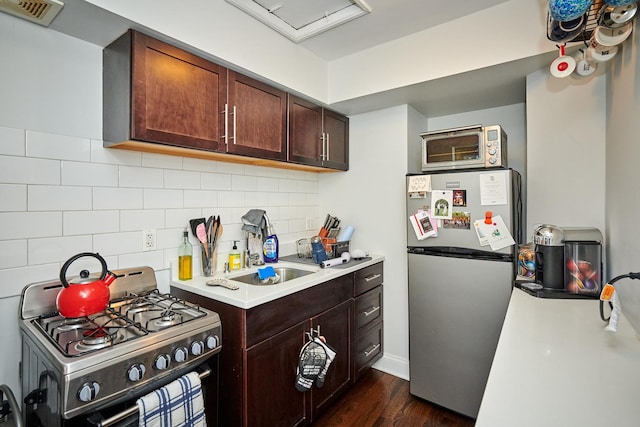 213 W Wisconsin St, Chicago, IL 60614 - kitchen with appliances with stainless steel finishes, light countertops, backsplash, dark wood-style flooring, and dark brown cabinetry