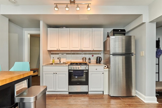 213 W Wisconsin St, Chicago, IL 60614 - kitchen featuring stainless steel appliances, a sink, light wood-style floors, and white cabinets