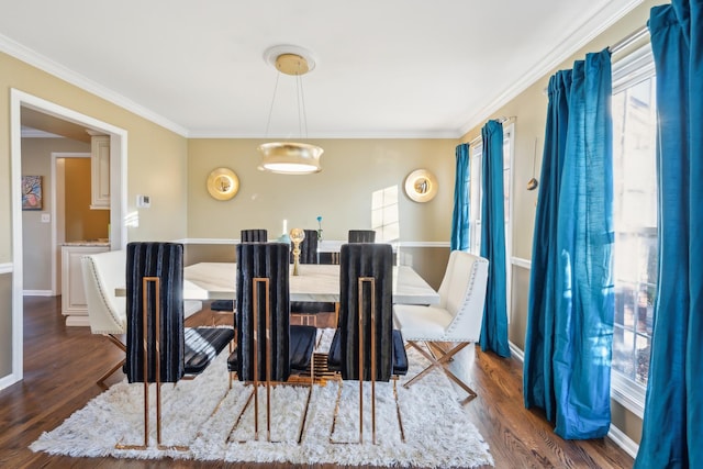 dining room with crown molding, dark wood-style flooring, and baseboards