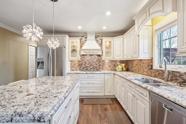 kitchen with stainless steel appliances, custom exhaust hood, a sink, dark wood-type flooring, and glass insert cabinets