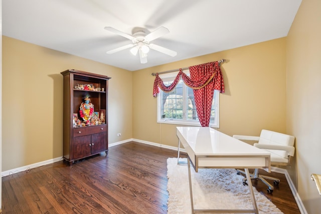 home office with a ceiling fan, dark wood-type flooring, and baseboards