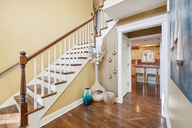 staircase with wood finished floors and baseboards