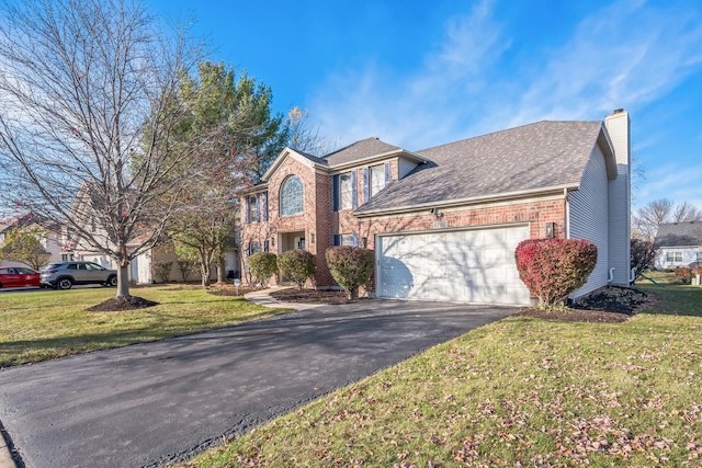 colonial home with asphalt driveway, a garage, a chimney, a front lawn, and a shingled roof