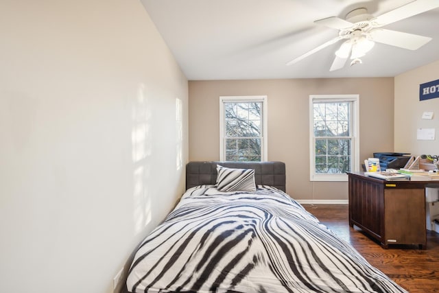 bedroom with dark wood-type flooring, baseboards, a ceiling fan, and an office area